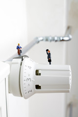 Radiator and small figurines. Businessman and consumer. Heating season concept. Heating battery.