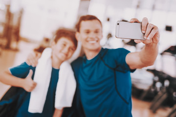 Young Father and Son Taking Selfie near Treadmills
