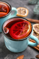 Metal cups of delicious mulled wine on grey table