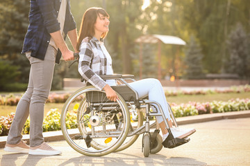 Young woman in wheelchair and her husband outdoors