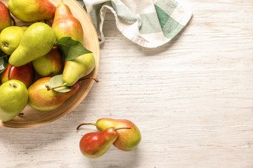 Plate with ripe pears on wooden table