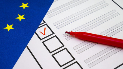 Voting in paper ballot by red pencil in European Union wirh EU flag