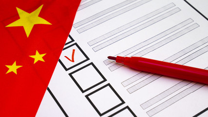 Voting in paper ballot by red pencil in China wirh Chinese flag
