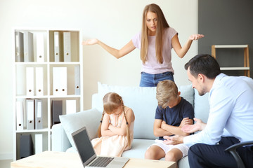 Displeased woman and her children meeting with headmaster at school