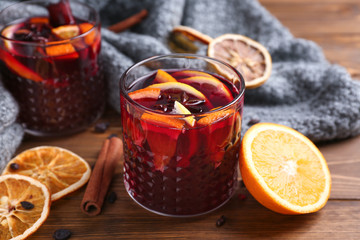 Glasses of delicious mulled wine on wooden table