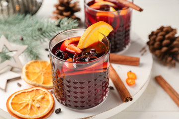 Glasses of delicious mulled wine on white board