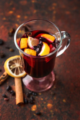 Glass cup of delicious mulled wine on color table