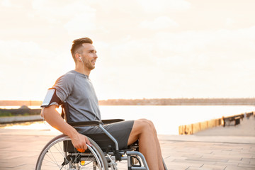 Young man in wheelchair listening to music outdoors