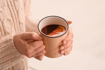 Woman holding metal cup of delicious mulled wine, closeup