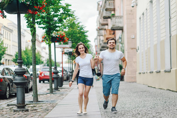 a guy and a girl are walking in the city in the summer