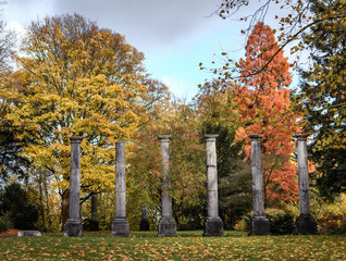 Alte Säulen zwischen Bäumen im Herbst