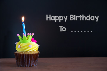 Cup cake and happy birthday to you text on chalkboard background..Birthday cupcake with a single...