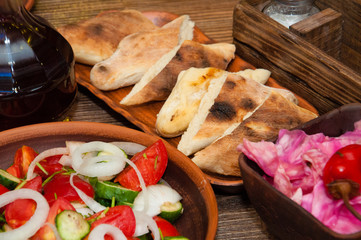 Salad of tomato, cucumber, onion, pepper, sauerkraut with buryak, khachapuri and wine. A dish of Georgian cuisine