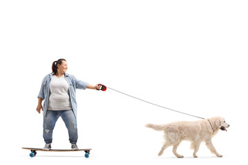 Young woman on a longboard walking a dog