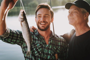 Old Father with Bearded Son Fishing on River.