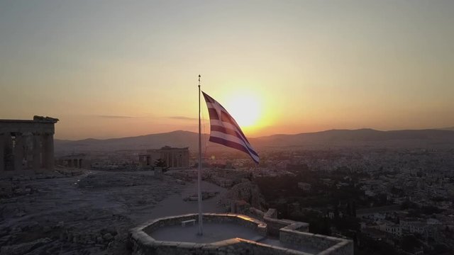 Temple and Greek flag beautifully at sunset.Athens Acropolis Parthenon evening