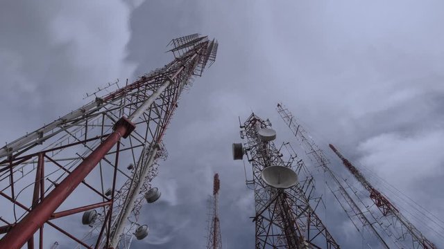 Antenna tower, low angle view. Telecommunication towers include of radio microwave and television antenna system in rain storm,4K time lapse.