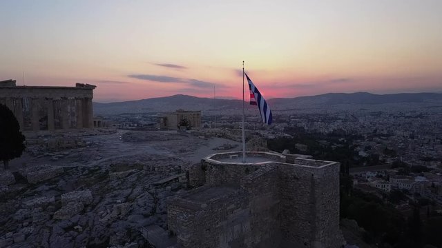 Temple and Greek flag beautifully at sunset.Athens Acropolis Parthenon evening