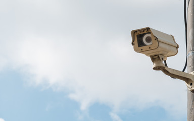 closed-circuit camera on white clouds background, closed-circuit camera on electric pole,