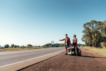 Hitchhiking couple. Backpackers on road