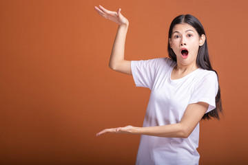 Surprise woman over orange background.