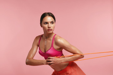 Workout. Woman Training With Resistance Bands On Pink Background