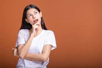 Thinking woman over orange background.