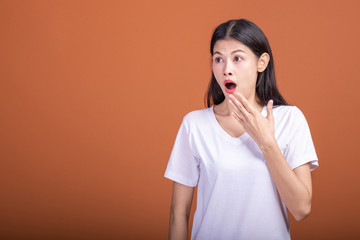 Surprise woman over orange background.