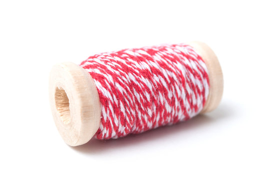 closeup of wooden bobbins of red cotton yarn