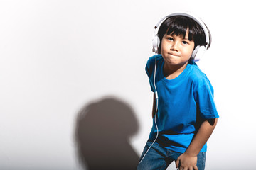 Young boy listening to music portrait in white background with hard light.