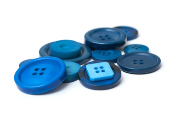 closeup of blue sewing buttons on white background
