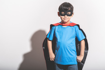 Young boy super hero portrait in white background with hard light.