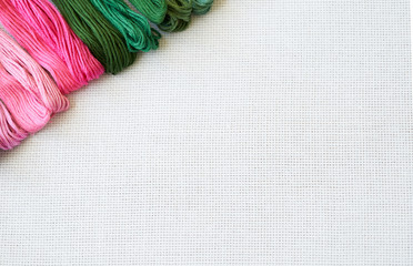 White fabric for cross stitch embroidery and colourful threads