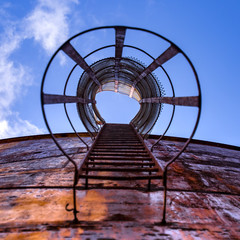 Obraz na płótnie Canvas Ladder of an old gas tank under clear blue sky