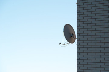 Satellite dish antenna on the brick wall