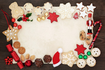 Christmas background border with festive symbols of tree decorations, biscuits, cakes, nuts,...