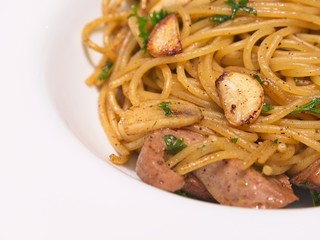 close up Italian cuisine, Spicy spaghetti with pork sausage and garlic in white bowl
