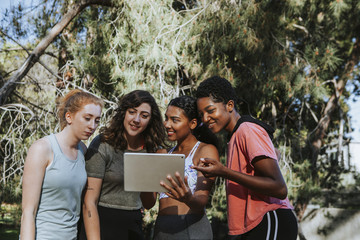 Group of active women looking at a digital tablet