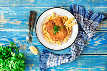 A piece of fried cod with fries on a plate.