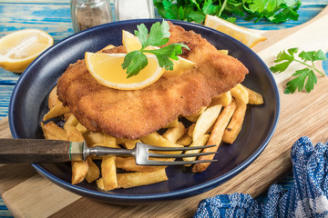 A piece of fried cod with fries on a plate.