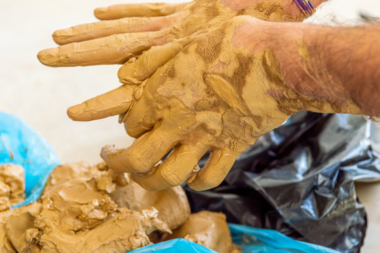 Male artist cleaning the clay on his hands