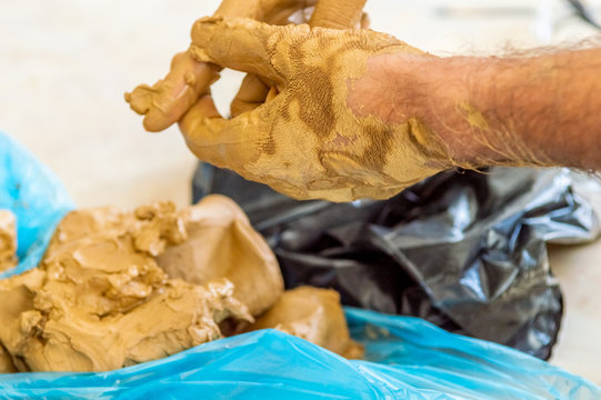 Male artist cleaning the clay on his hands