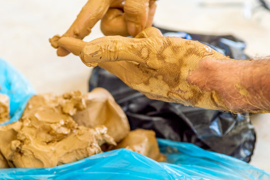 Male artist cleaning the clay on his hands