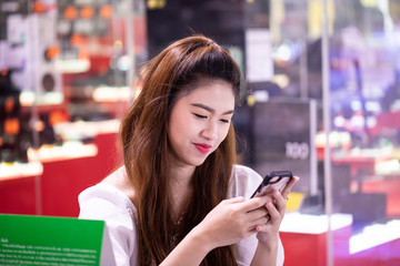Portrait of Beautiful Attractive Asian woman smile and using smartphone feeling so happiness and fun