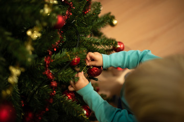 Little boy decorating Christmas tree