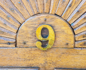 Number nine close up shot on oak wood entering gate .