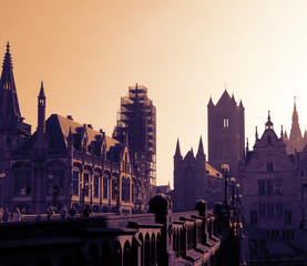 Beautiful skyline of Ghent, Belgian city, tourists walking. Cityscape  - old European town - misty morning in autumn. Toned image,  high angle.