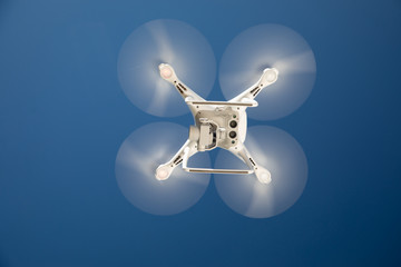 Drone Quadcopter From Below Against A Blue Sky