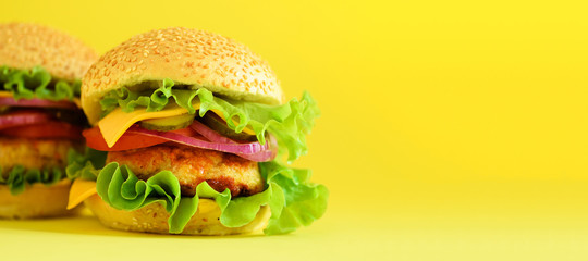 Fast food banner. Juicy meat burgers with cheese, lettuce on yellow background. Take away meal....