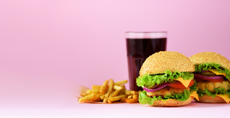 Fast food banner. Juicy meat burgers, french fries potatoes and cola drink on pink background. Take...